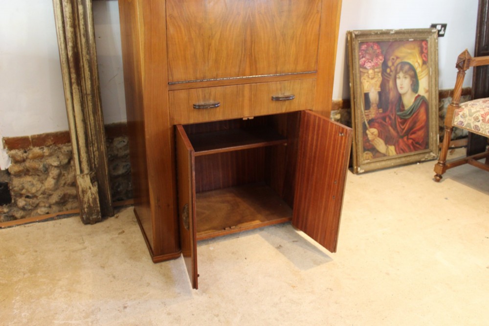 An Art Deco walnut bureau featuring a fall-front writing compartment above a single drawer and a two-door cupboard. View VI