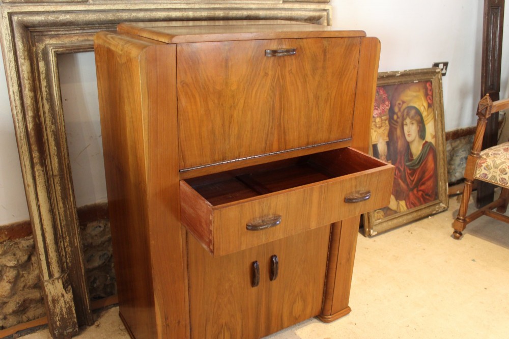 An Art Deco walnut bureau featuring a fall-front writing compartment above a single drawer and a two-door cupboard. View VII
