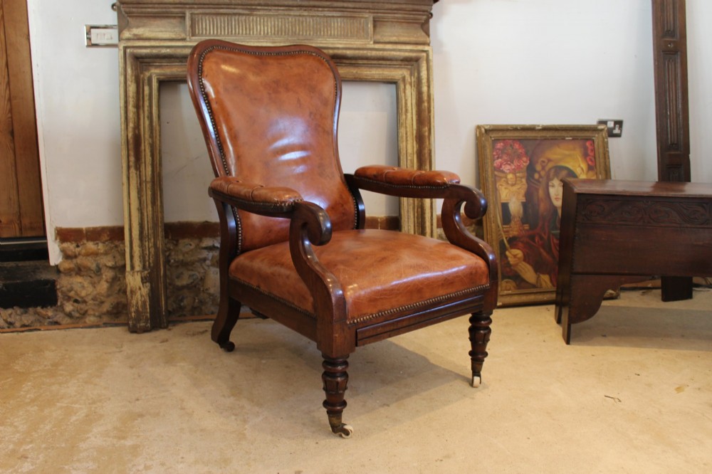 A William IV leather reclining armchair with carved mahogany frame, scrolled arms, brass stud trim, turned front legs, and castors. View XII