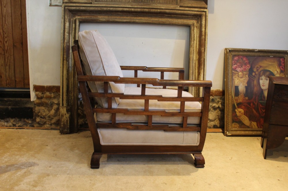 An Art Deco solid walnut armchair featuring grid-pattern side panels, squared feet, and beige suede seat and back cushions. View VII