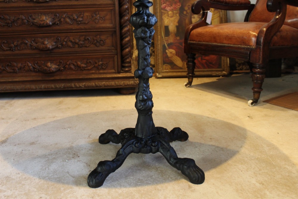 A pair of circular garden tables featuring polished grey granite tops supported by ornate black cast iron pedestal bases with claw feet. View VII