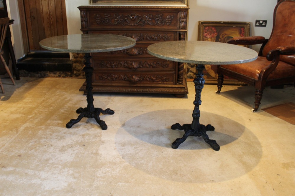 A pair of circular garden tables featuring polished grey granite tops supported by ornate black cast iron pedestal bases with claw feet. View XI
