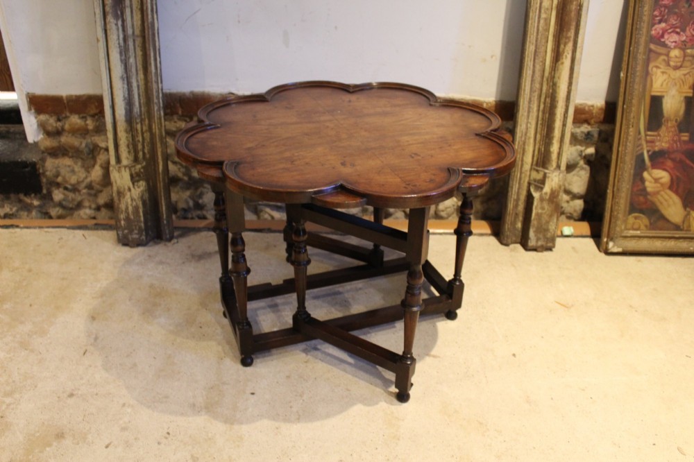 A late Victorian walnut occasional table featuring a scalloped multi-lobed top with a raised rim, supported by turned legs and cross stretchers. View II