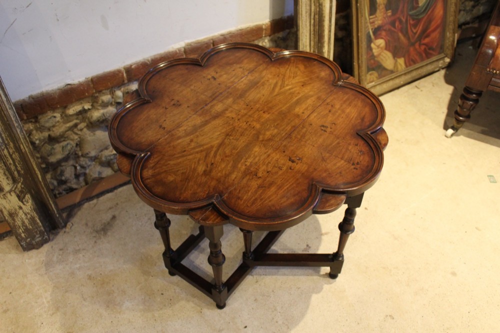 A late Victorian walnut occasional table featuring a scalloped multi-lobed top with a raised rim, supported by turned legs and cross stretchers. View VII