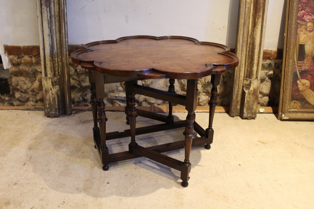 A late Victorian walnut occasional table featuring a scalloped multi-lobed top with a raised rim, supported by turned legs and cross stretchers. View XI