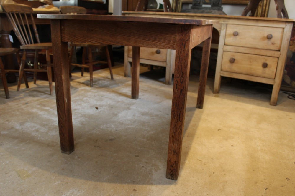 An Edwardian light oak dining table featuring a rectangular top with subtly curved short ends, supported by four straight square legs. View VI