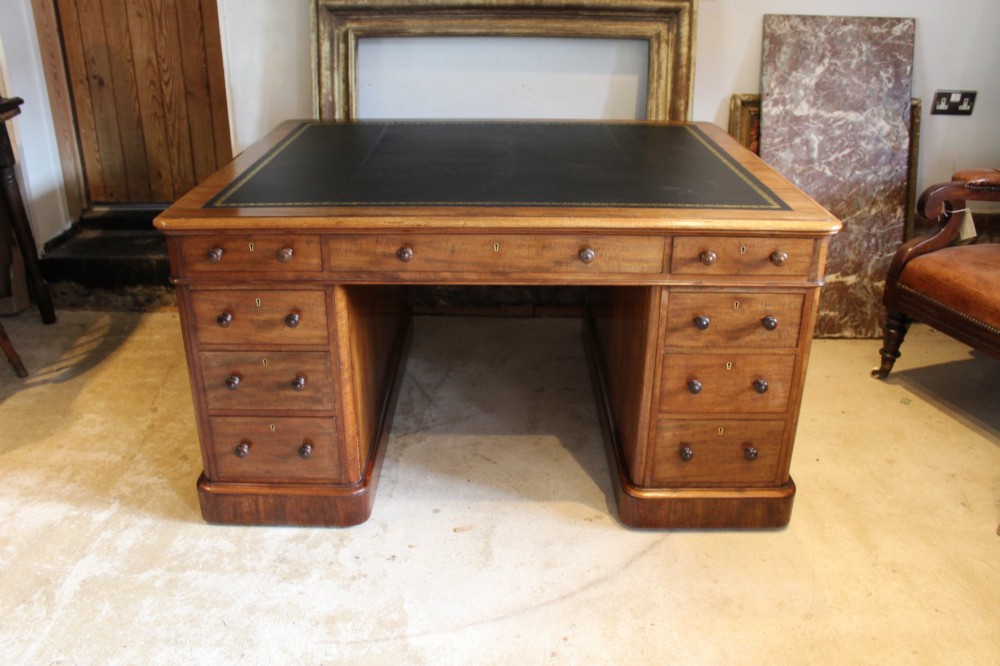 An early Victorian mahogany partners desk featuring a black leather writing top, twin pedestals with multiple drawers, and turned wooden handles. View XIII