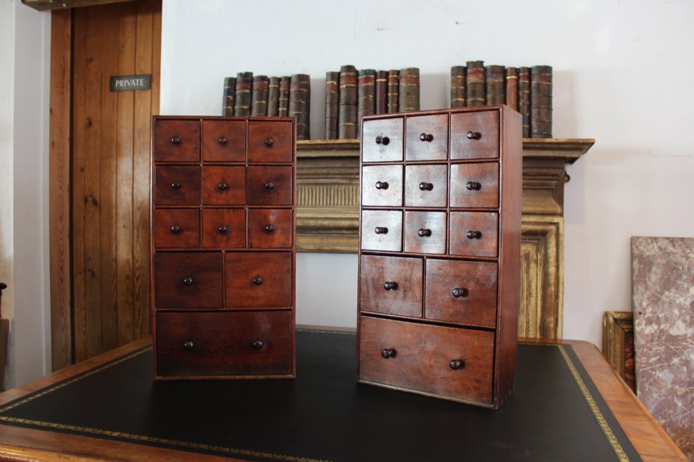 A pair of matching early nineteenth-century tabletop wooden apothecary chests featuring multiple small drawers with turned wooden knobs and a warm brown finish. View VIII