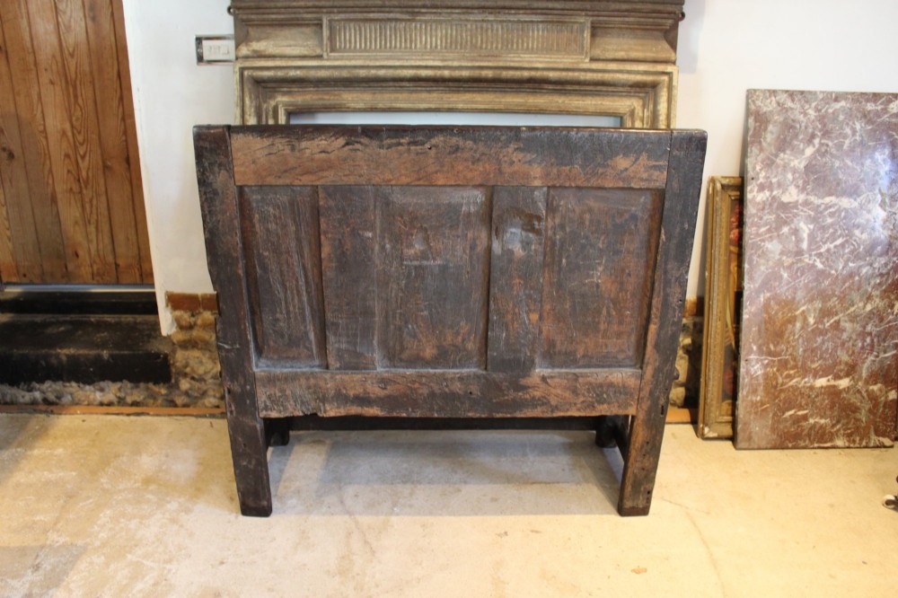 A dark oak 17th-century style settle bench with a three-panel backrest, shaped armrests, and wooden stretchers. View VIII