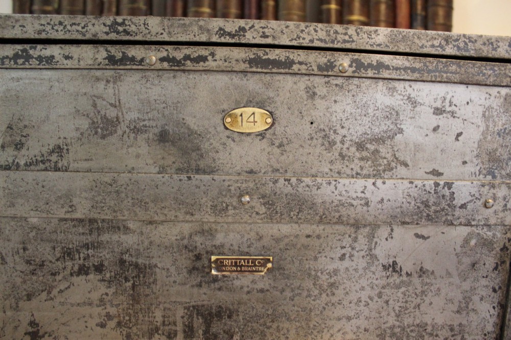 A tall, narrow Victorian industrial metal cupboard featuring a single door with a dark grey patinated surface, riveted frame, brass number plaque, and latch handle. View II