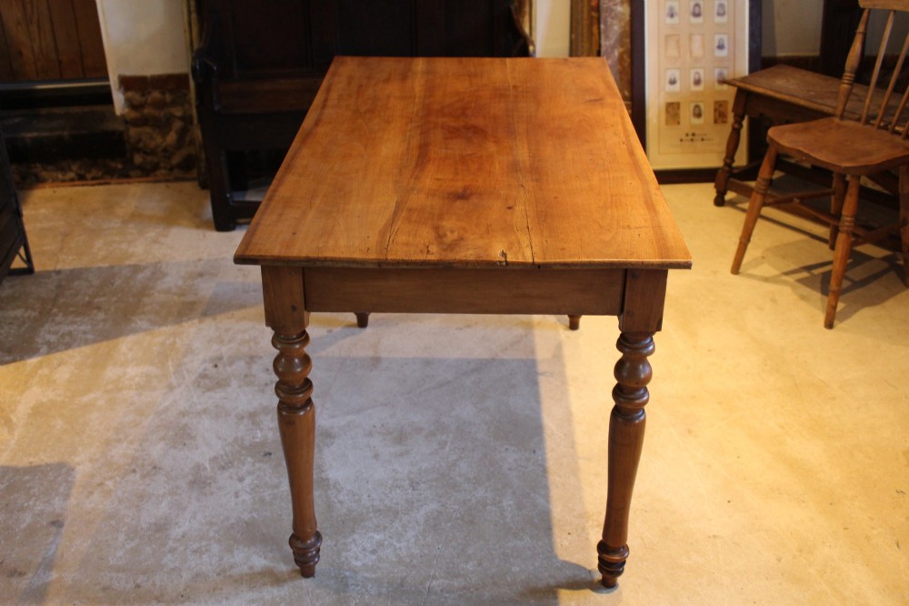 A rectangular French cherry wood dining table featuring four turned legs and a single frieze drawer. View III