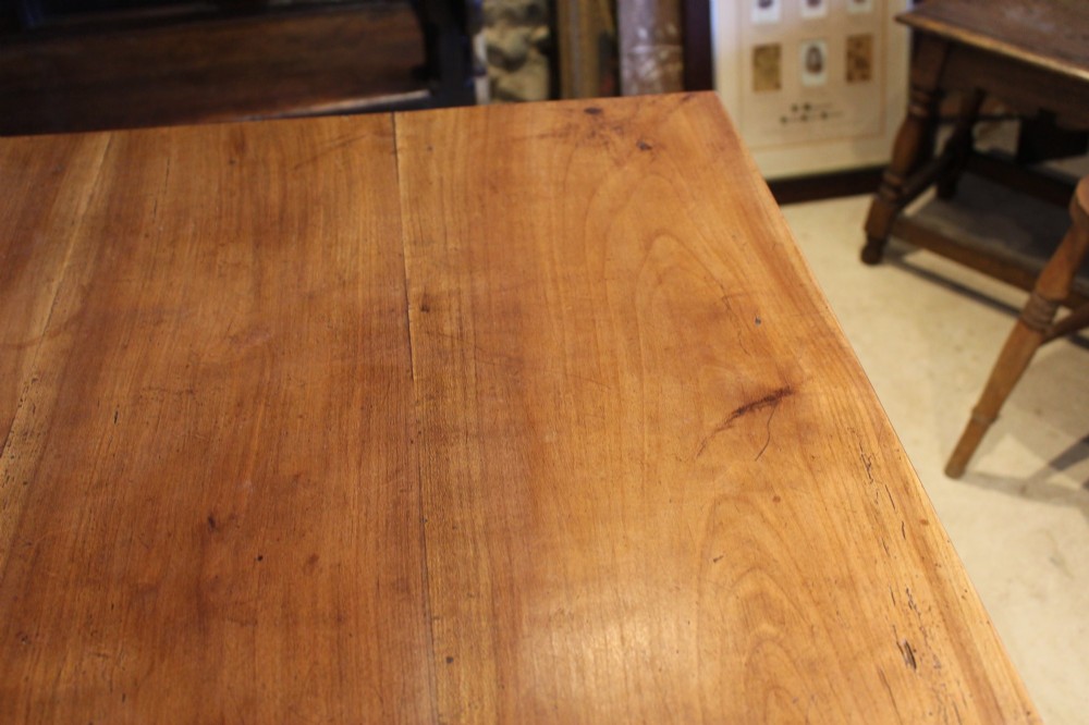A rectangular French cherry wood dining table featuring four turned legs and a single frieze drawer. View IV