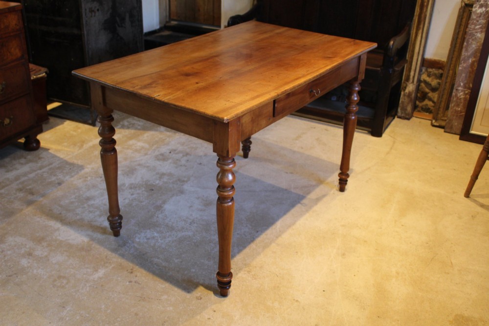 A rectangular French cherry wood dining table featuring four turned legs and a single frieze drawer. View VIII