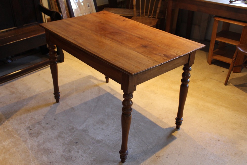 A rectangular French cherry wood dining table featuring four turned legs and a single frieze drawer. View IX