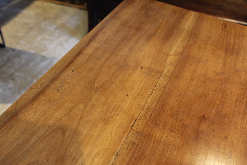 A rectangular French cherry wood dining table featuring four turned legs and a single frieze drawer. View X