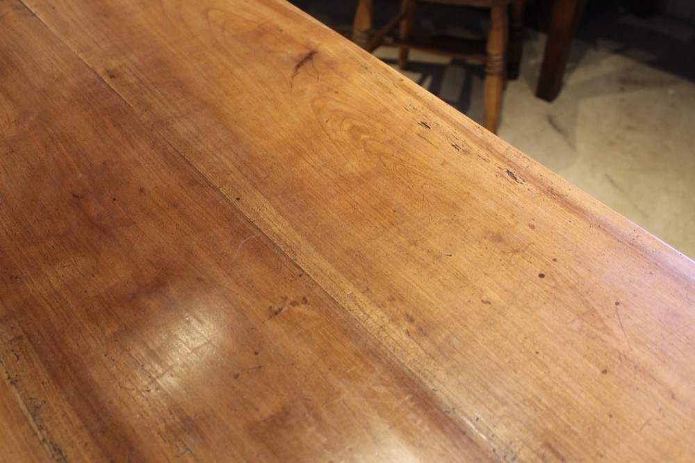 A rectangular French cherry wood dining table featuring four turned legs and a single frieze drawer. View XII