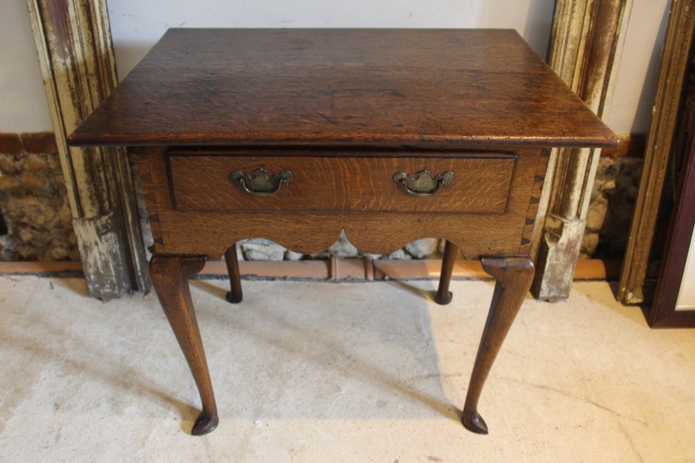 A George II oak lowboy table featuring a single drawer with brass handles, a scalloped apron, and slender cabriole legs ending in pad feet. View II