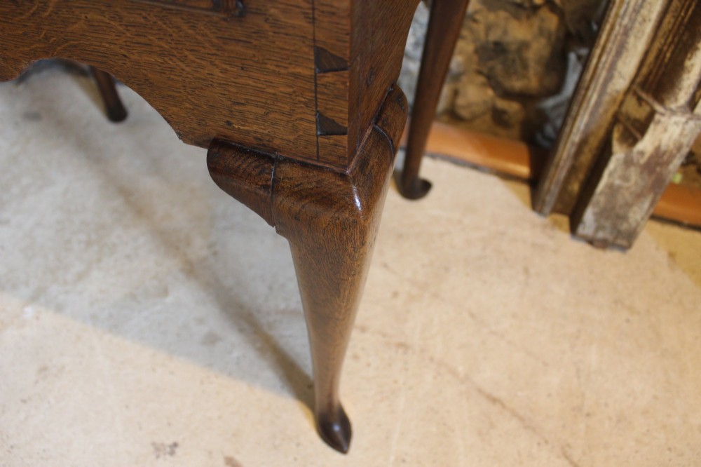 A George II oak lowboy table featuring a single drawer with brass handles, a scalloped apron, and slender cabriole legs ending in pad feet. View VI