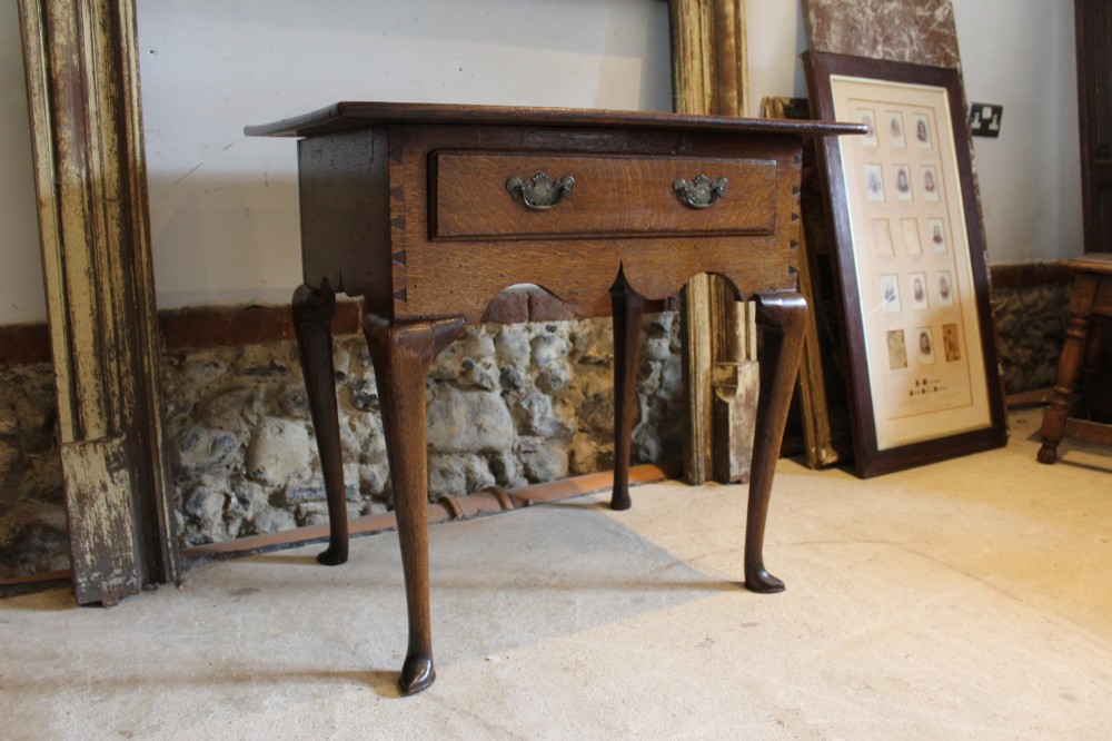 A George II oak lowboy table featuring a single drawer with brass handles, a scalloped apron, and slender cabriole legs ending in pad feet. View VII