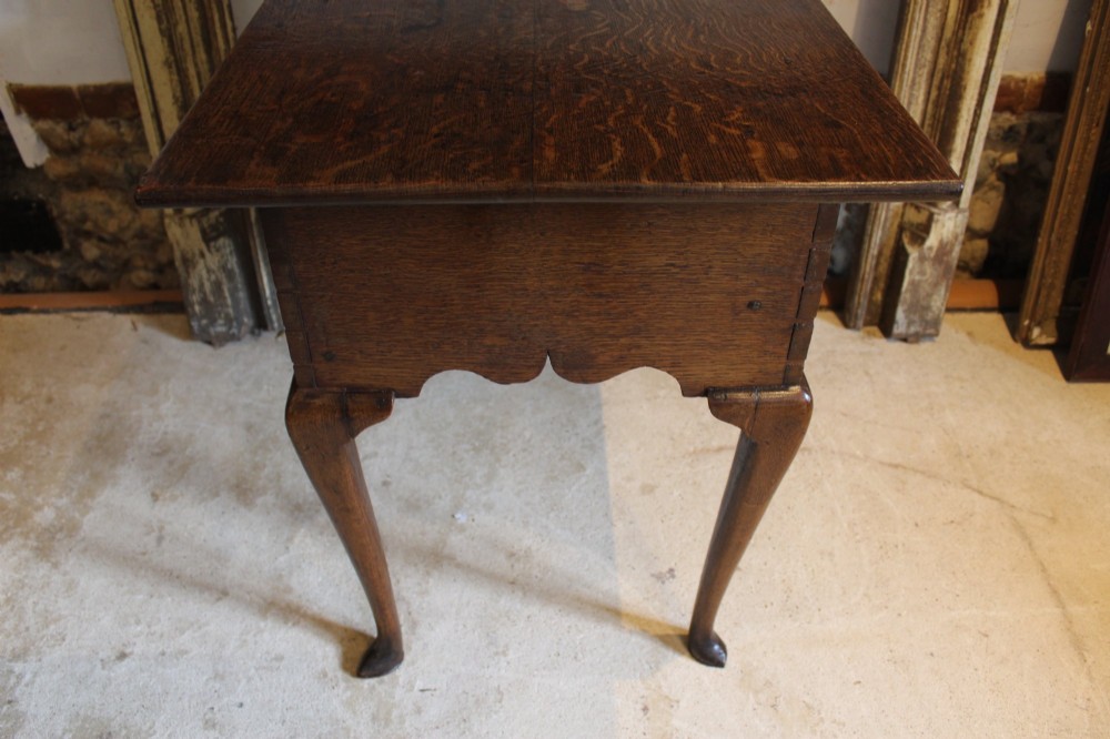 A George II oak lowboy table featuring a single drawer with brass handles, a scalloped apron, and slender cabriole legs ending in pad feet. View IX