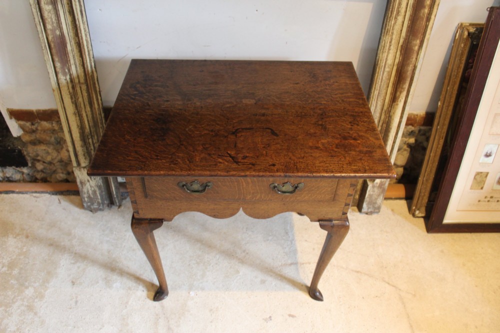 A George II oak lowboy table featuring a single drawer with brass handles, a scalloped apron, and slender cabriole legs ending in pad feet. View XII