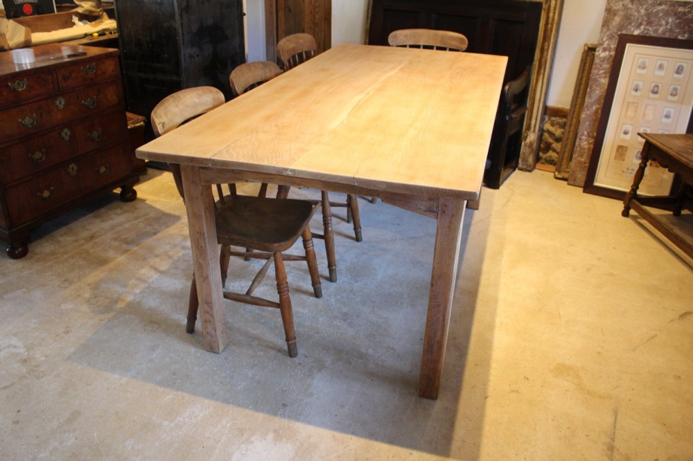 An Edwardian light oak farmhouse refectory dining table featuring straight square legs and a spacious rectangular plank top. View VII