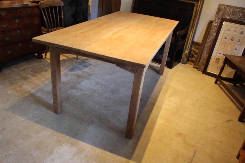 An Edwardian light oak farmhouse refectory dining table featuring straight square legs and a spacious rectangular plank top. View VIII