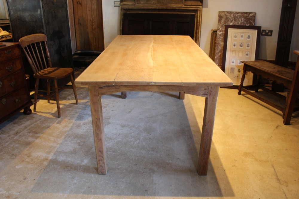 An Edwardian light oak farmhouse refectory dining table featuring straight square legs and a spacious rectangular plank top. View XII