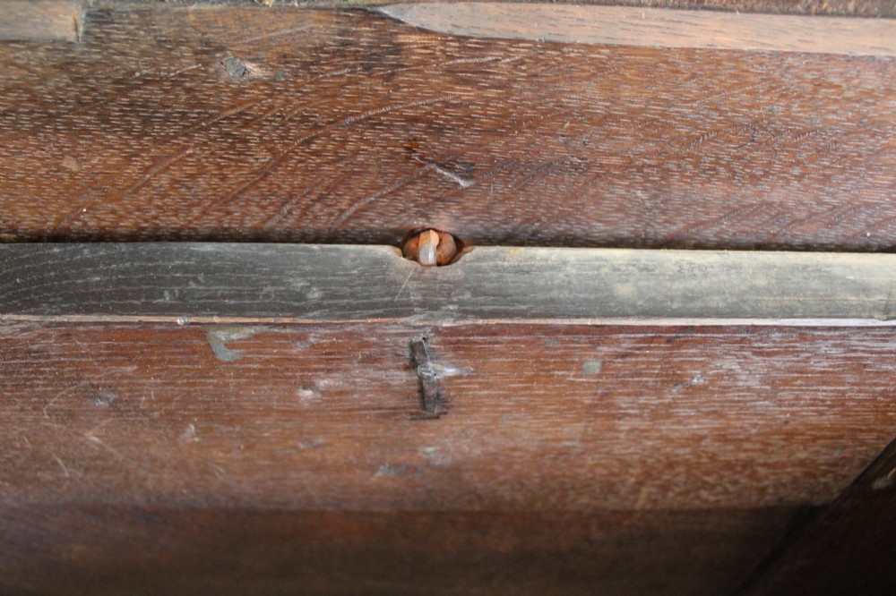 A 17th-century dark oak coffer featuring carved front panels and a four-panel hinged lid. View VI