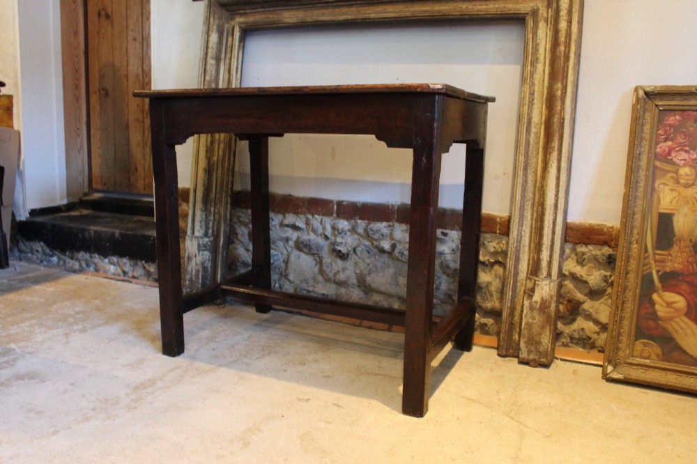 A dark oak George I side table featuring a rectangular plank top, pegged mortise and tenon joinery, and square legs joined by lower stretchers. View IX
