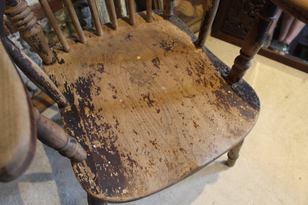 A pair of late 19th-century Windsor armchairs featuring shaped elm seats, spindle backs, turned legs, and distressed dark brown patinated finish. View VI