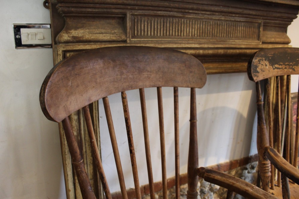 A pair of late 19th-century Windsor armchairs featuring shaped elm seats, spindle backs, turned legs, and distressed dark brown patinated finish. View IX