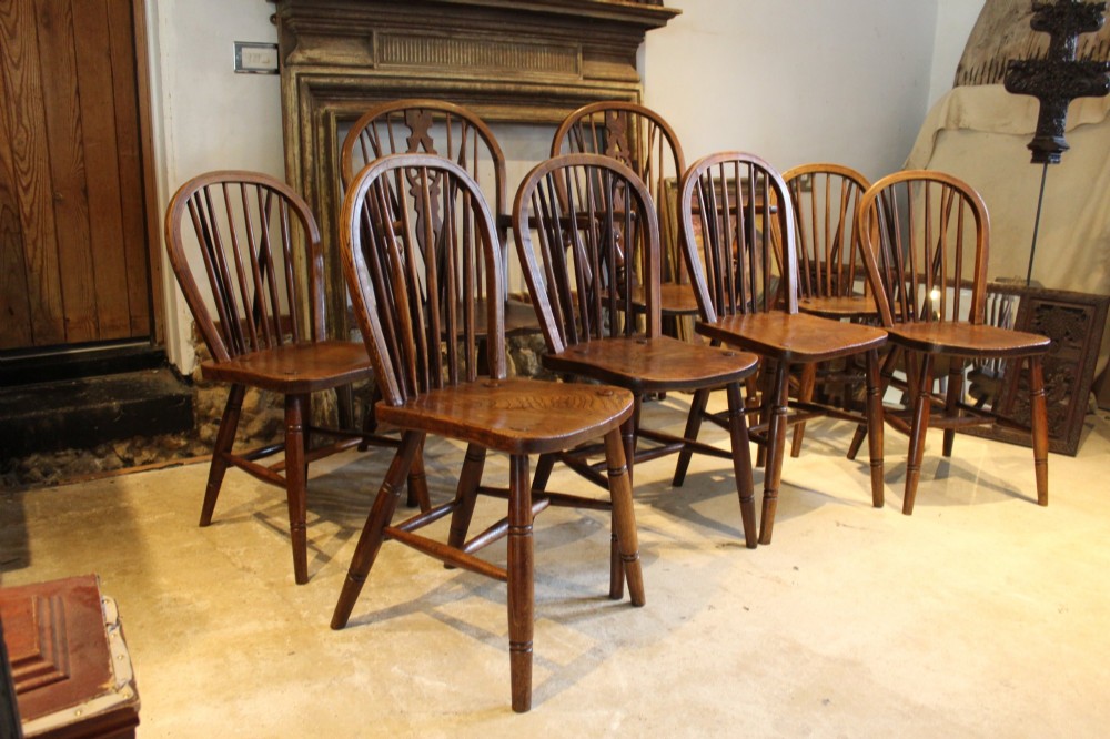 A set of eight Edwardian elm and beech Windsor dining chairs, including two armchairs and six side chairs, featuring hoop backs with spindle uprights and turned legs. View II