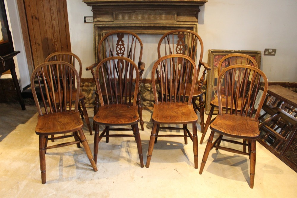A set of eight Edwardian elm and beech Windsor dining chairs, including two armchairs and six side chairs, featuring hoop backs with spindle uprights and turned legs. View III
