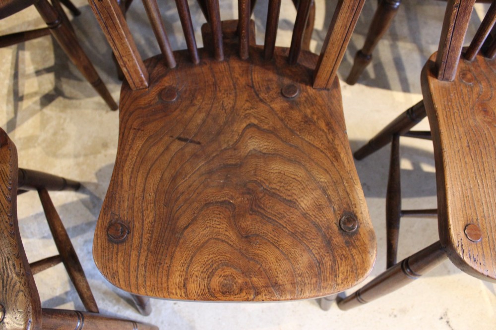 A set of eight Edwardian elm and beech Windsor dining chairs, including two armchairs and six side chairs, featuring hoop backs with spindle uprights and turned legs. View IV