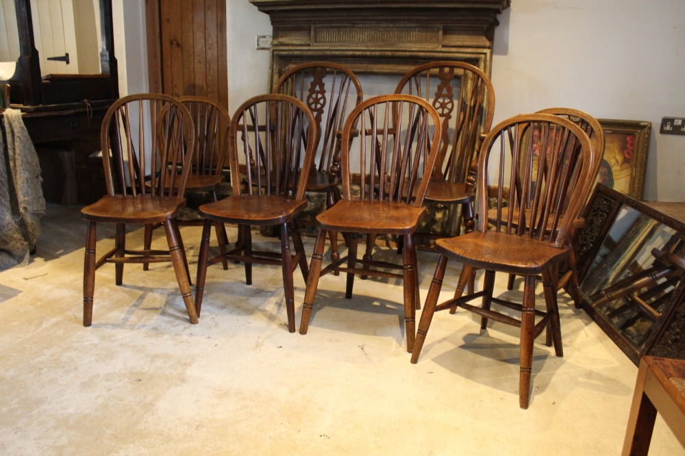 A set of eight Edwardian elm and beech Windsor dining chairs, including two armchairs and six side chairs, featuring hoop backs with spindle uprights and turned legs. View VIII