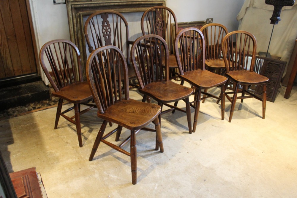 A set of eight Edwardian elm and beech Windsor dining chairs, including two armchairs and six side chairs, featuring hoop backs with spindle uprights and turned legs. View IX