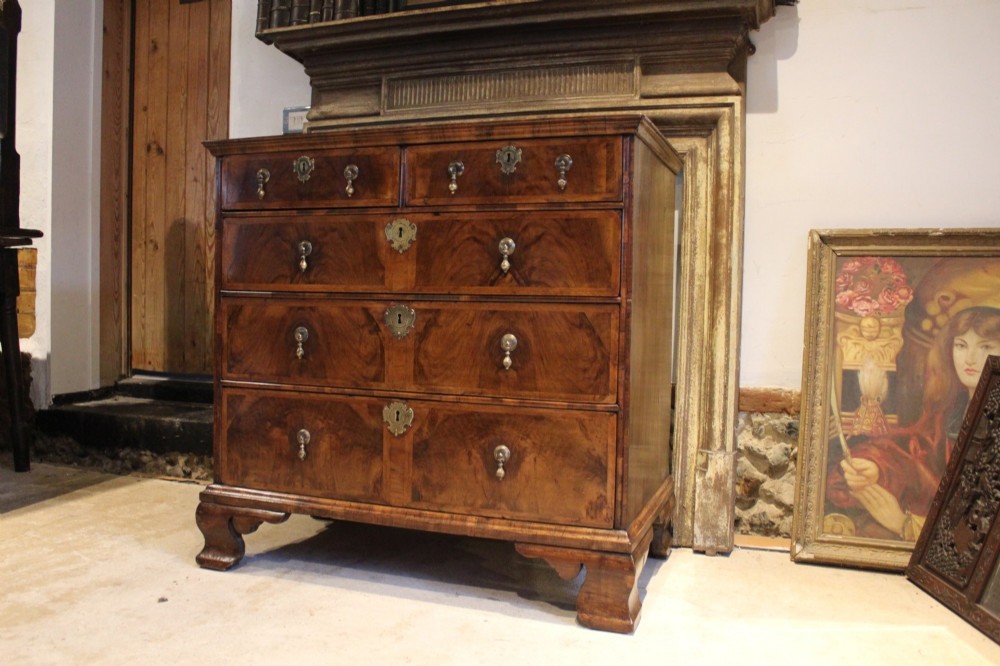 An 18th-century George II burr walnut chest of drawers featuring two short over three long graduated drawers on bracket feet. View II