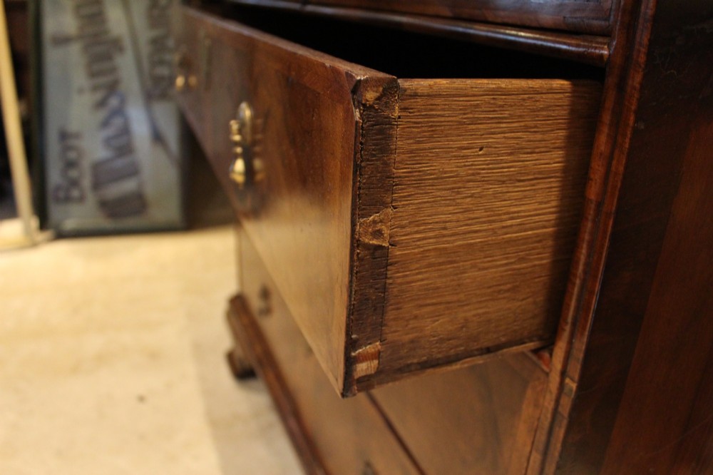 An 18th-century George II burr walnut chest of drawers featuring two short over three long graduated drawers on bracket feet. View IV