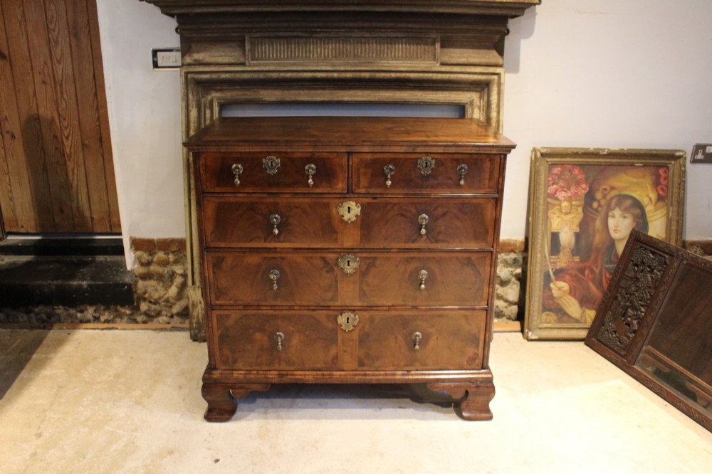 An 18th-century George II burr walnut chest of drawers featuring two short over three long graduated drawers on bracket feet. View VII