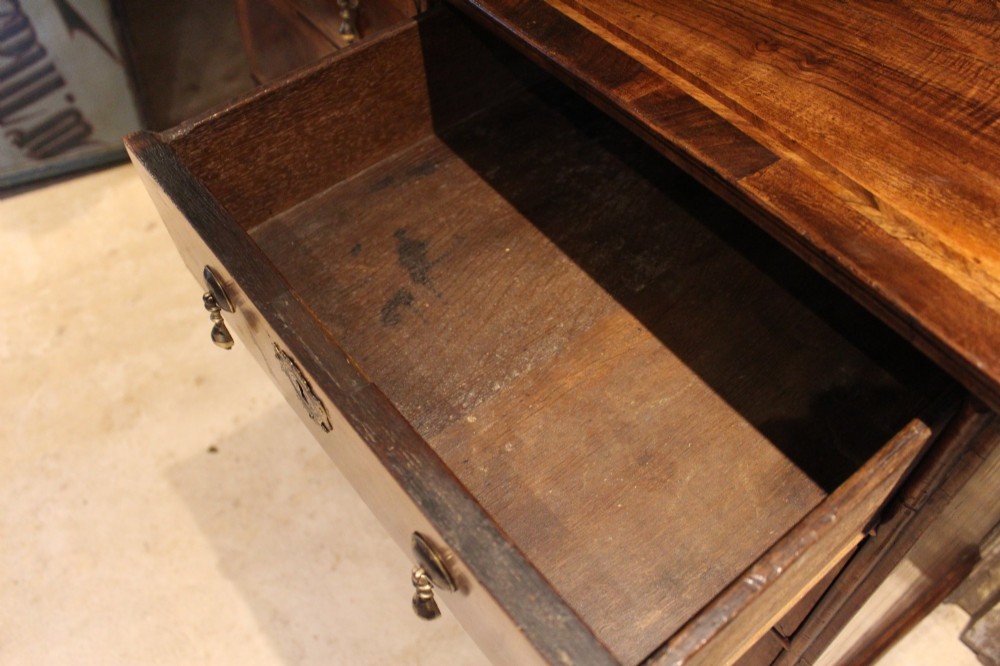 An 18th-century George II burr walnut chest of drawers featuring two short over three long graduated drawers on bracket feet. View XI