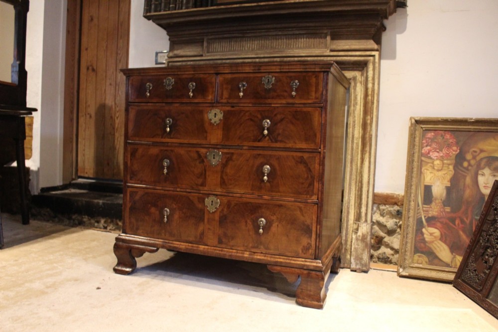 An 18th-century George II burr walnut chest of drawers featuring two short over three long graduated drawers on bracket feet. View XII