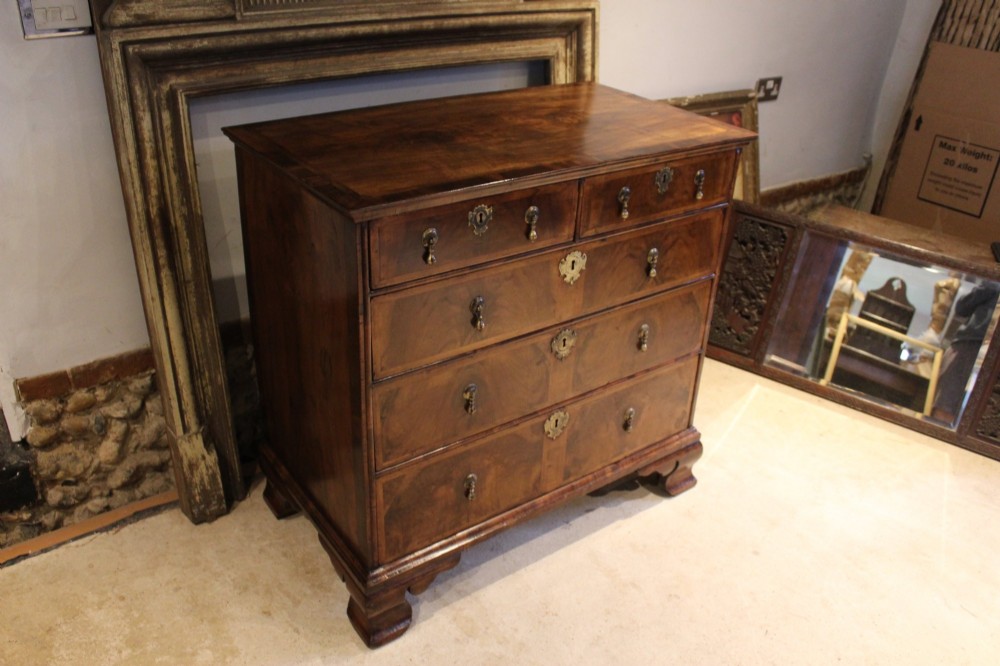 An 18th-century George II burr walnut chest of drawers featuring two short over three long graduated drawers on bracket feet. View XIII