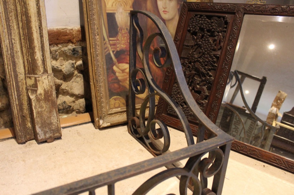A large dark steel fire fender featuring decorative scrolling ironwork along the front and side returns. View II