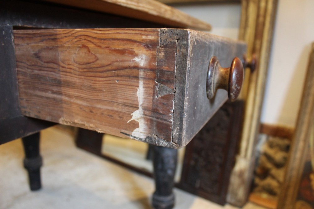 A 19th-century pine farmhouse dining table featuring a natural scrubbed wooden top, frieze drawers with round wooden knobs, and turned dark painted legs. View VIII