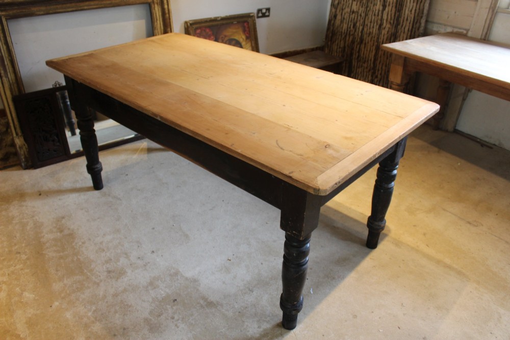 A 19th-century pine farmhouse dining table featuring a natural scrubbed wooden top, frieze drawers with round wooden knobs, and turned dark painted legs. View XIII