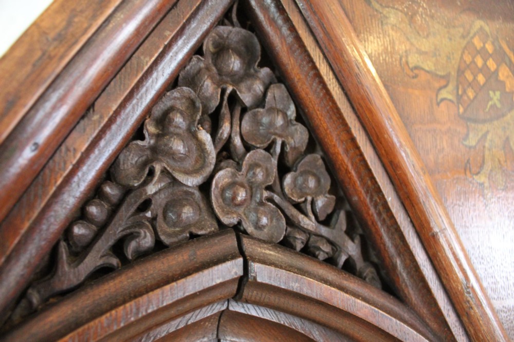 A pair of arched dark oak architectural panels featuring carved Gothic tracery and polychrome paintings of mounted medieval knights and heraldic shields. View VIII