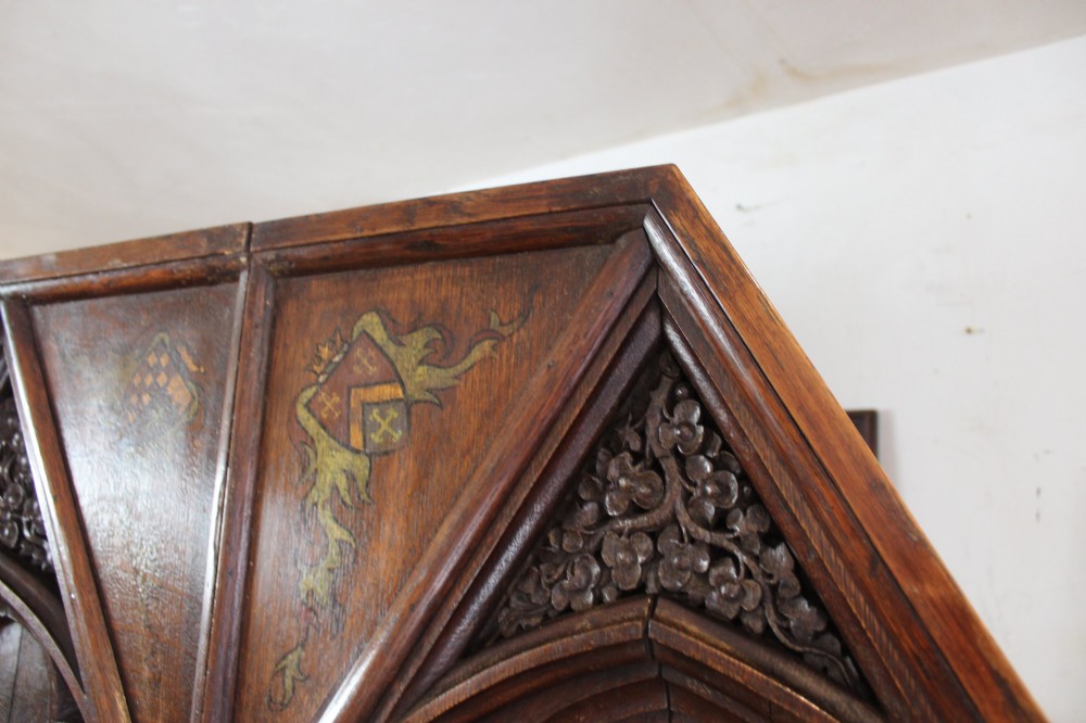 A pair of arched dark oak architectural panels featuring carved Gothic tracery and polychrome paintings of mounted medieval knights and heraldic shields. View XI