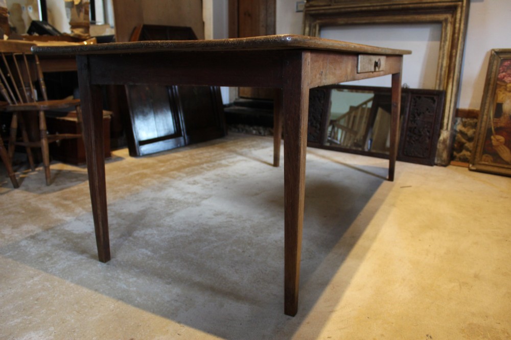 An antique French oak refectory dining table featuring a solid two-plank top, a side frieze drawer, and square tapered legs. View VIII