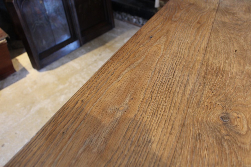 An antique French oak refectory dining table featuring a solid two-plank top, a side frieze drawer, and square tapered legs. View XII